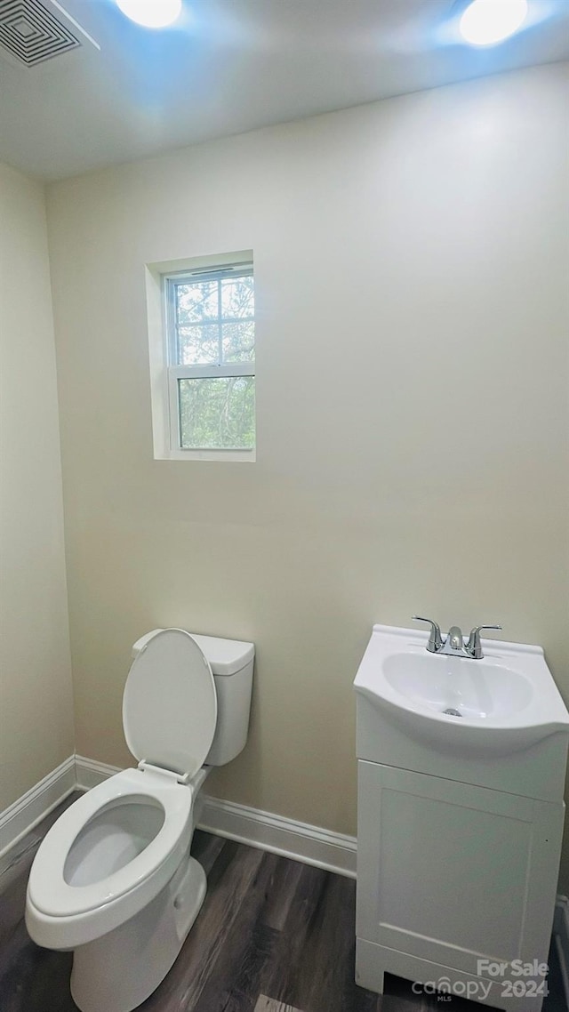 bathroom with hardwood / wood-style flooring, vanity, and toilet