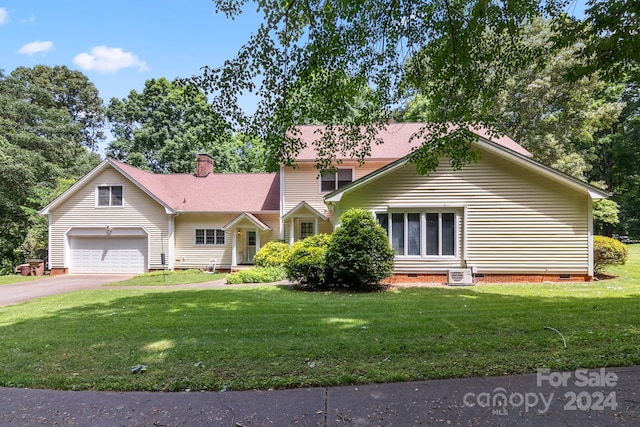 view of front of property with a garage, central AC, and a front lawn