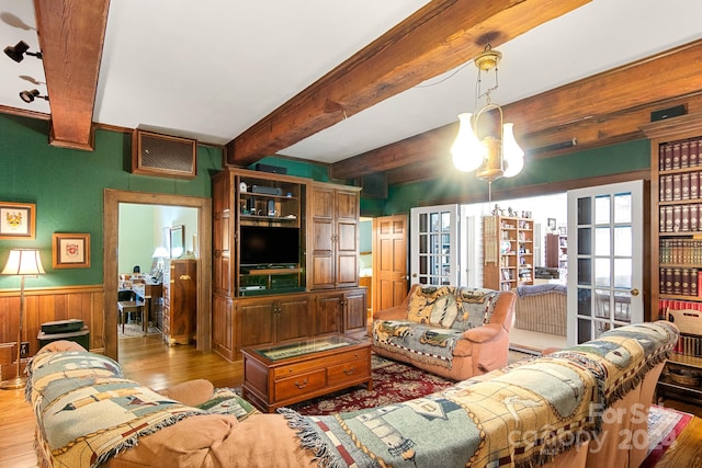 living room featuring beamed ceiling, french doors, and wood-type flooring