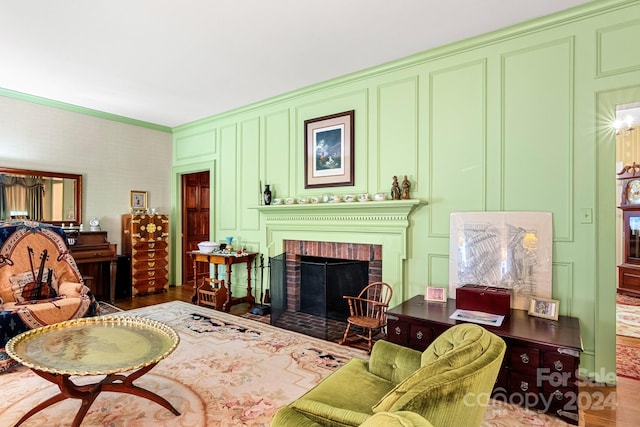 living room featuring hardwood / wood-style flooring, a fireplace, and ornamental molding