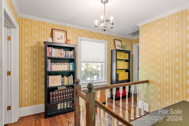 hall with a notable chandelier, crown molding, and hardwood / wood-style flooring