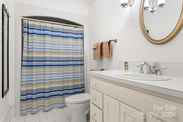 bathroom with crown molding, tile flooring, toilet, and vanity with extensive cabinet space