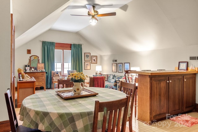 dining area featuring ceiling fan, vaulted ceiling, and light tile flooring