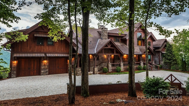 691 Dogwood Ln, Blowing Rock, NC 28605 - view of front of property featuring a shingled roof, an attached garage, driveway, and stone siding
