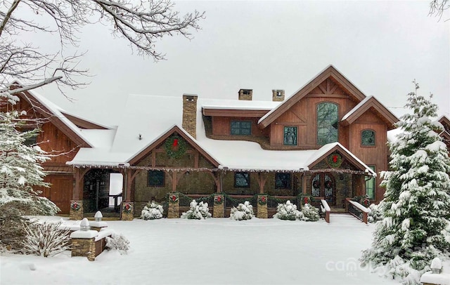 691 Dogwood Ln, Blowing Rock, NC 28605 - snow covered back of property featuring a chimney, a porch, and stone siding