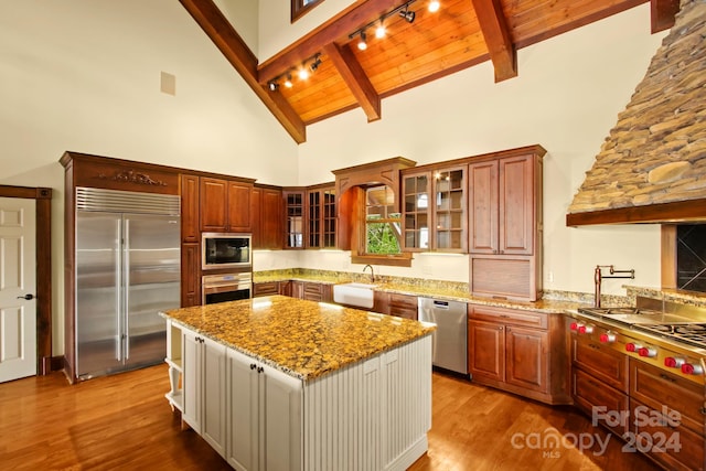 kitchen with a center island, rail lighting, wooden ceiling, built in appliances, and high vaulted ceiling