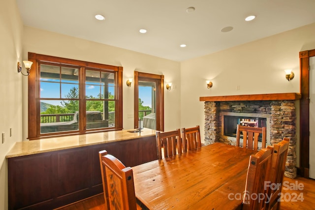 dining room with hardwood / wood-style floors and a fireplace