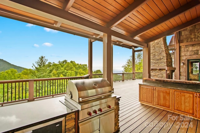 deck with an outdoor kitchen and a grill