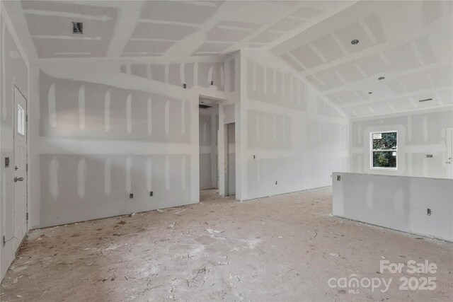 unfurnished living room featuring vaulted ceiling