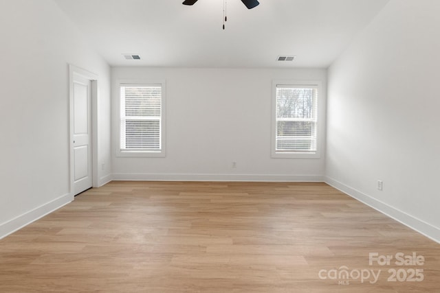 spare room featuring a wealth of natural light, ceiling fan, and light wood-type flooring