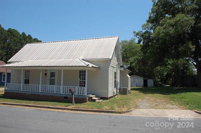 view of front of home featuring a front lawn, central AC, and covered porch