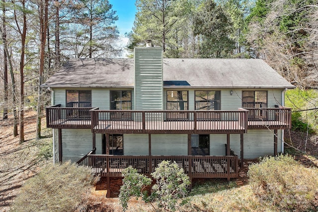 rear view of house with a chimney and a wooden deck