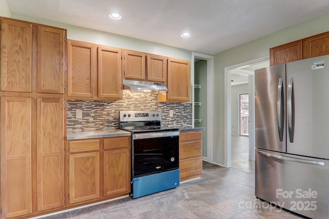 kitchen featuring recessed lighting, under cabinet range hood, stainless steel appliances, light countertops, and decorative backsplash