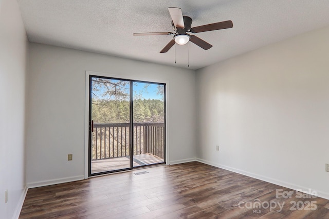 unfurnished room featuring a textured ceiling, wood finished floors, visible vents, and baseboards