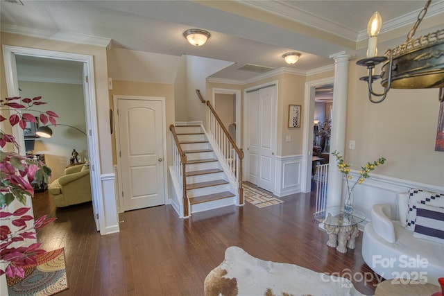 entrance foyer with ornamental molding, ornate columns, and dark wood-type flooring