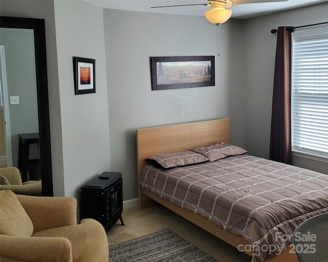 carpeted bedroom featuring multiple windows and ceiling fan