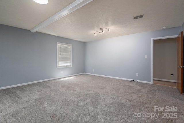 carpeted spare room with beam ceiling and a textured ceiling