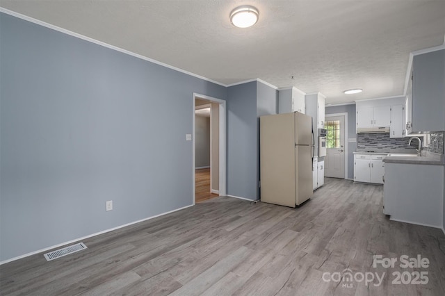 kitchen featuring white cabinetry, white appliances, ornamental molding, and light wood-type flooring