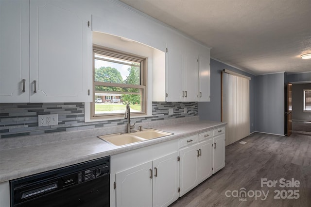 kitchen featuring dark wood-type flooring, sink, white cabinetry, black dishwasher, and backsplash