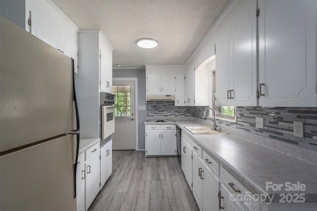 kitchen with stainless steel appliances, white cabinetry, plenty of natural light, and sink