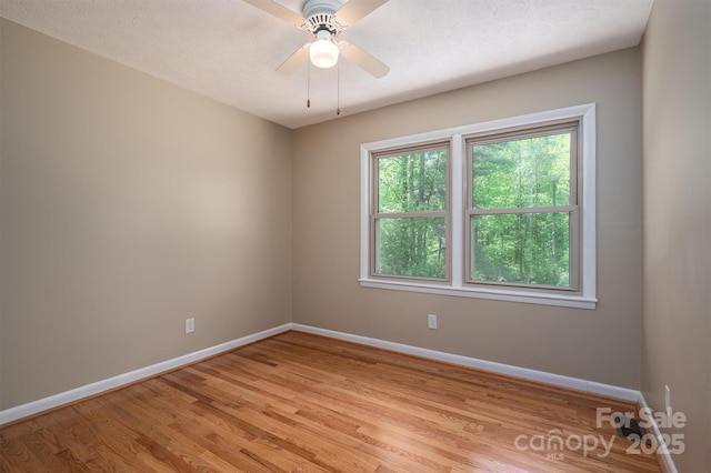 unfurnished room with ceiling fan, light hardwood / wood-style floors, and a textured ceiling