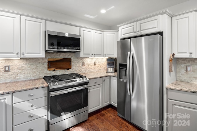 kitchen with white cabinets, dark hardwood / wood-style floors, backsplash, and appliances with stainless steel finishes