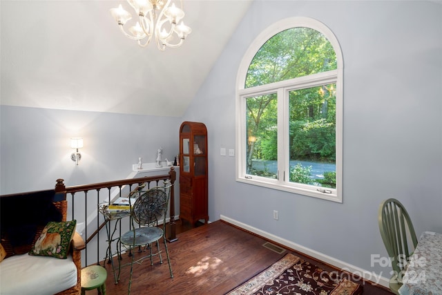 sitting room featuring hardwood / wood-style flooring, a chandelier, a wealth of natural light, and vaulted ceiling