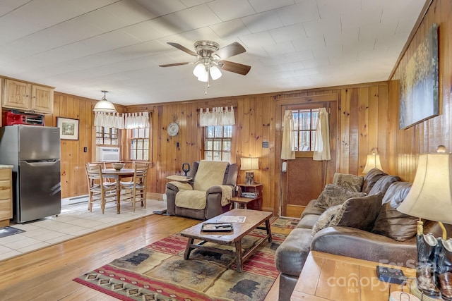 living room featuring tile flooring, ceiling fan, and wooden walls