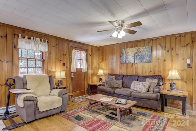 living room with a baseboard radiator, wood walls, ceiling fan, and hardwood / wood-style flooring