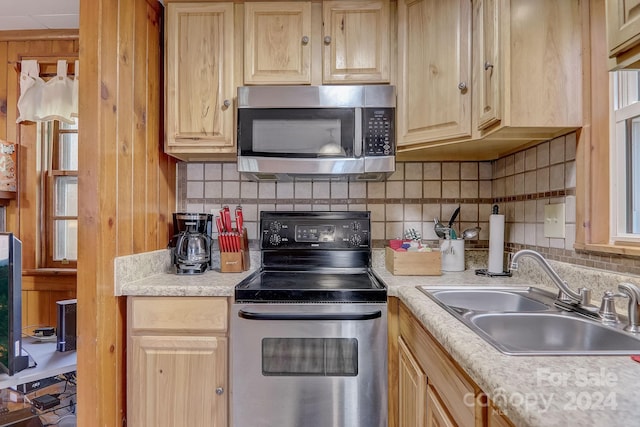 kitchen with tasteful backsplash, appliances with stainless steel finishes, light brown cabinets, and sink