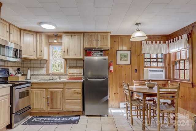 kitchen featuring light brown cabinets, light tile flooring, pendant lighting, and stainless steel appliances