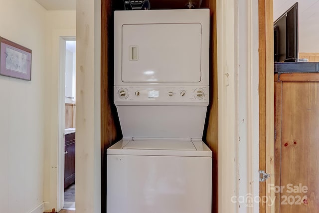 clothes washing area with stacked washer and clothes dryer