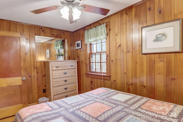 bedroom with wooden walls and ceiling fan