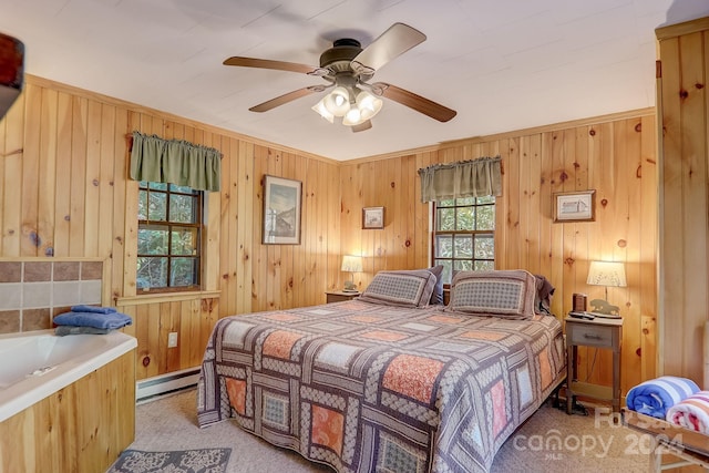 bedroom featuring light colored carpet, ceiling fan, wooden walls, and baseboard heating