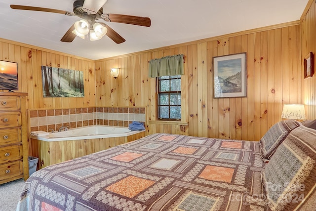 carpeted bedroom with wood walls, crown molding, and ceiling fan