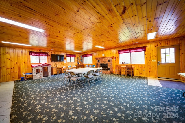 unfurnished dining area with wood ceiling, wooden walls, tile flooring, and a fireplace