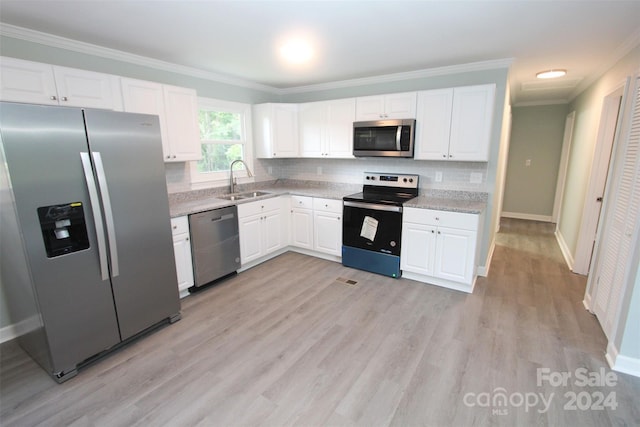 kitchen featuring tasteful backsplash, sink, light hardwood / wood-style flooring, stainless steel appliances, and white cabinets