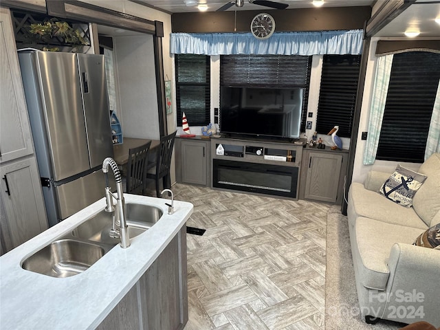 living room featuring ceiling fan, sink, and light parquet flooring