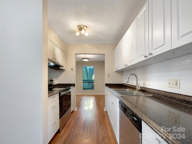 kitchen featuring white cabinets, light hardwood / wood-style flooring, stainless steel appliances, sink, and a textured ceiling