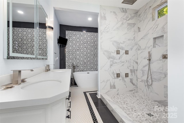 bathroom with tile patterned floors, vanity, and a bath