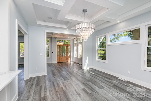 unfurnished dining area with dark hardwood / wood-style flooring, an inviting chandelier, and coffered ceiling