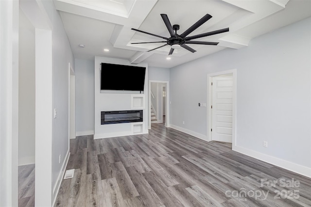 unfurnished living room with ceiling fan, beamed ceiling, light hardwood / wood-style floors, and coffered ceiling