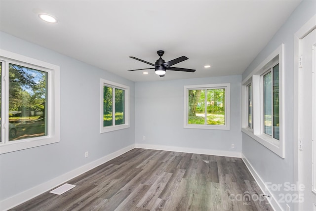 unfurnished room featuring ceiling fan, plenty of natural light, and hardwood / wood-style flooring