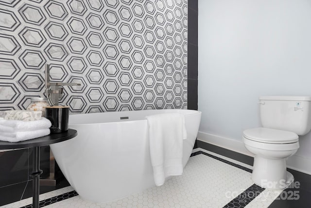 bathroom with a tub, tile patterned flooring, and toilet