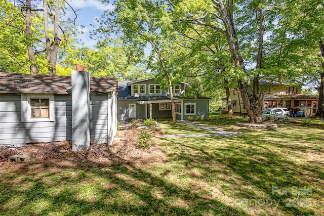 rear view of property with a yard