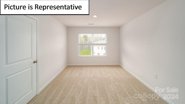 unfurnished room featuring light carpet