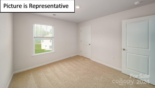 spare room featuring light colored carpet