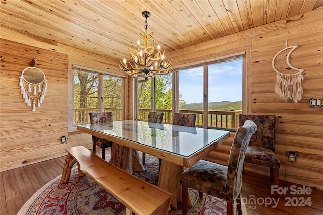 dining area with a notable chandelier, hardwood / wood-style flooring, and wooden ceiling