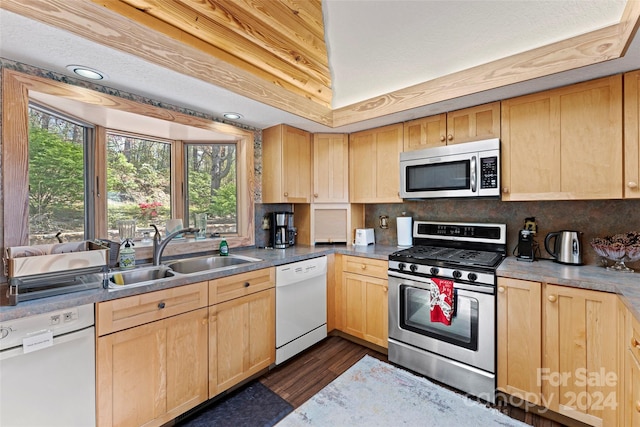 kitchen featuring appliances with stainless steel finishes, backsplash, dark wood-type flooring, light brown cabinetry, and sink