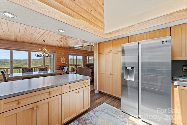 kitchen featuring log walls, wood ceiling, decorative light fixtures, stainless steel fridge, and dark hardwood / wood-style floors